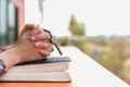 Close up young hands holding wooden cross over holy bible and praying. christian concept Royalty Free Stock Photo