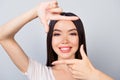 Close up of young, happy, beautiful, brunette woman making frame Royalty Free Stock Photo