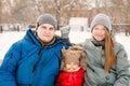 Close-up of young happy family with one toddler in winter casual oufit posing outdoors