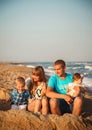 Close up of young happy loving family with small kids, having fun at beach together near the ocean, happy lifestyle family concept Royalty Free Stock Photo