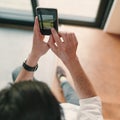 Close up of young hipster guy taking photo on his mobile phone camera of a beautiful landscape through the window Royalty Free Stock Photo