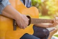 Young hipster man practiced guitar in the park,happy and enjoy playing guitar.