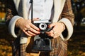 Close-up young hipster woman holding retro film camera, taking photo outdoors. Girl photographer and vintage camera, hobby Royalty Free Stock Photo