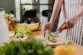 Close up on young housewife woman hands slicing cucumber with kitchen knife Royalty Free Stock Photo