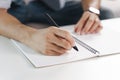 Close up of young man in casual cloth hands writing down on the notepad, notebook using ballpoint pen on the table Royalty Free Stock Photo