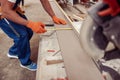 Male builder hands measuring wooden plank at construction site Royalty Free Stock Photo