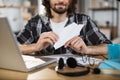 Close up of young man doing paper plane while sitting at table with laptop and documents. Royalty Free Stock Photo