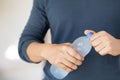 Close up young man hand holding cool fresh drinking water bottle from a plastic. Open up, drink,