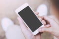 Close up of a young man hand holding using mobile smart phone with screen empty cell phone. he sitting chair in public park Royalty Free Stock Photo