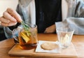 Close up young man hand putting rosemary into the hot tea for afternoon tea time break, cozy at home