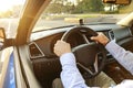 Car interior with male driver sitting behind the wheel, soft sunset light. Luxurious vehicle dashboard and electronics. Royalty Free Stock Photo