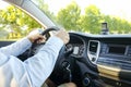 Car interior with male driver sitting behind the wheel, soft sunset light. Luxurious vehicle dashboard and electronics. Royalty Free Stock Photo