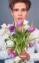 Close-up, a young man holds in a rumpled broken bouquet of tulips