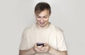 Close up of a young man leaning against a grey wall using mobile phone. Portrait of a happy business man holding a smartphone. Man Royalty Free Stock Photo