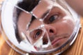 Reflection Of A Man`s Face In Broken Mirror Royalty Free Stock Photo