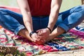 Close up of young man lower body practice yoga outdoor by lake stretching hips pose