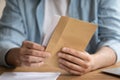 Close up young man opening envelope, feeling curious.