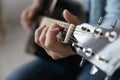 Close up young man playing guitar, learning chords.