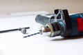 Close up of young man is preparing electric drill and changing drill bit