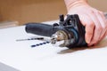 Close up of young man is preparing electric drill and changing drill bit