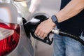 Close-up of young man refuelling a car at a petrol station. Middle selection of human hand hold fuel pump Royalty Free Stock Photo