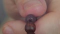 Close up of a young man`s hand, fingering a wooden rosary