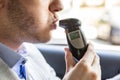 Man Sitting Inside Car Taking Alcohol Test