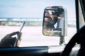 Close up of young man smiling and having fun using his phone or device driving his car at the beach with the sea or oceanand the Royalty Free Stock Photo