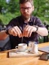 A young man sweetens his drink in a cafe Royalty Free Stock Photo
