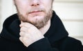 Close-up, a young man touches his beard with his hand. Royalty Free Stock Photo