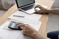 Close up young man using calculator summarizing domestic utility bills. Royalty Free Stock Photo