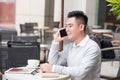 Close up of Young Man using telephone look out the window. or Business man Contact Customer. Royalty Free Stock Photo