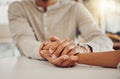 Close up of young man and woman holding hands at wooden table, from above. Loving couple expressing empathy Royalty Free Stock Photo