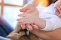 Close up young mother hold hand of small tiny cute baby son daughter. Mom holding innocent child in arms, hugging kid with love, Royalty Free Stock Photo