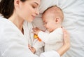 Close-up, a young mother hugs her baby, on the bed together Royalty Free Stock Photo