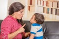 Close up of young mother talking with his little boy over a black sofa Royalty Free Stock Photo