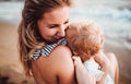 Close-up of young mother with a toddler girl on beach on summer holiday. Royalty Free Stock Photo