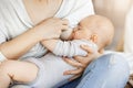 Close up of young mother who breastfeed her little kid. Touching scene of maternity love and caring. Family, motherhood Royalty Free Stock Photo