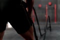 Close up of a Young muscle athlete doing working out with crossfit ropes