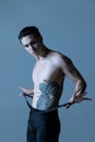 Close-up young muscled man, male ballet dancer posing isolated on old navy studio background. Art, motion, inspiration Royalty Free Stock Photo