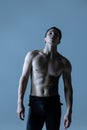 Close-up young muscled man, male ballet dancer posing isolated on old navy studio background. Art, motion, inspiration Royalty Free Stock Photo