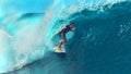 CLOSE UP: Young pro surfboarder rides a breathtaking barrel wave in Tahiti. Royalty Free Stock Photo