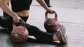 Close-up young professional athletic woman doing split stretch exercise on kettlebells on gym floor slow motion. Royalty Free Stock Photo