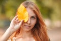 Red-haired girl closes her eyes with autumn leaves Royalty Free Stock Photo