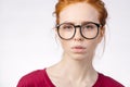 Redhead woman in glasses with hair knot looking at camera on white background Royalty Free Stock Photo