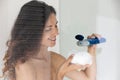 Woman squeezing douche gel on washcloth before taking a shower