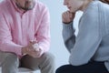 Close-up of a young sad woman sharing her grief with a psychotherapy specialist during an individual counseling meeting.