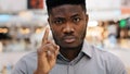 Close-up young serious angry african american man sternly looking at camera disapprovingly shaking finger showing Royalty Free Stock Photo