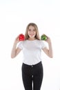 A close up of young and smiling woman who is holding red and green bell peppers. Healthy diet and vitamins. Vegetarian food.