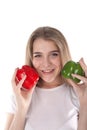 A close up of young and smiling woman who is holding red and green bell peppers. Healthy diet and vitamins. Vegetarian food. Royalty Free Stock Photo